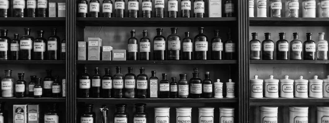 Vintage apothecary shelves packed with labeled medicine bottles